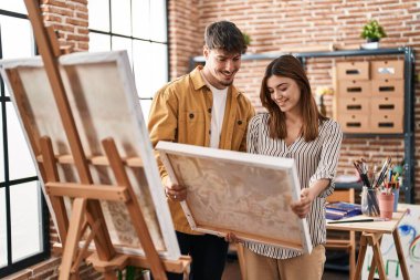 Sanat stüdyosunda kendine güvenen, gülümseyen bir kadın sanatçı.