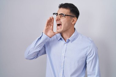 İş kıyafetleri ve gözlük takan yakışıklı İspanyol adam el ve ağızla bağırıp çağırıyordu. iletişim konsepti. 