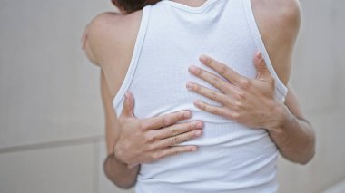 Soyutlanmış beyaz arka planda birbirine sarılan iki erkek.