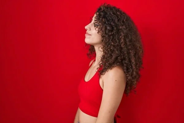 Spaanse Vrouw Met Krullend Haar Staan Rode Achtergrond Zoek Naar — Stockfoto