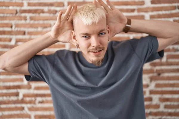 Homem Caucasiano Jovem Sobre Parede Tijolos Tentando Ouvir Ambas Mãos — Fotografia de Stock