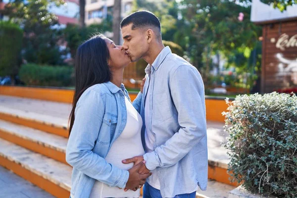 Young Latin Couple Expecting Baby Touching Belly Kissing Park — Foto Stock