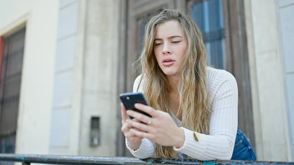 Mujer Rubia Joven Usando Smartphone Con Expresión Seria Calle —  Fotos de Stock