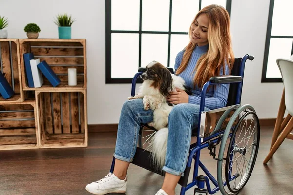 若いです白人女性座っています車椅子に触れ犬に自宅で — ストック写真