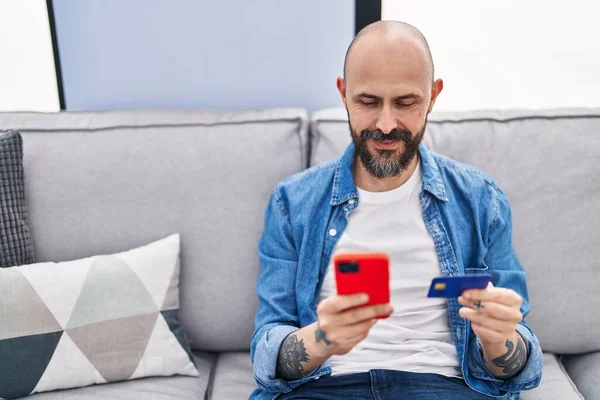 Young Bald Man Using Smartphone Credit Card Sitting Sofa Home — Fotografia de Stock