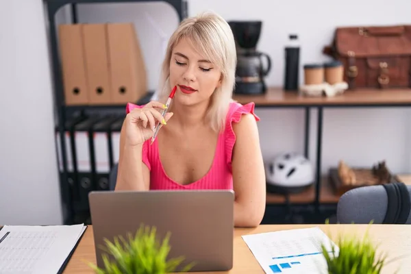 Genç Sarışın Kadını Ofiste Şüpheli Bir Ifadeyle Çalışırken Dizüstü Bilgisayar — Stok fotoğraf
