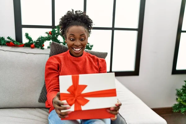 African American Woman Unpacking Christmas Gift Sitting Sofa Home — Foto Stock