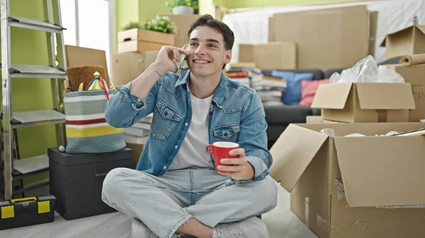 Young Hispanic Man Talking Smartphone Drinking Coffee New Home — Stok fotoğraf