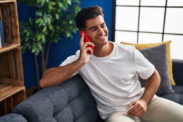 Young Hispanic Man Talking Smartphone Sitting Sofa Home — Stockfoto