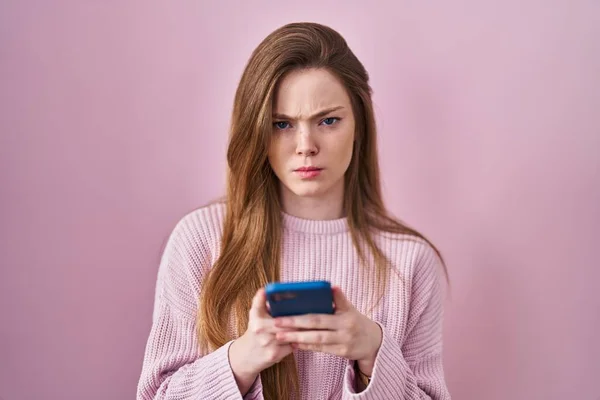 年轻的高加索女人用智能手机打字时充满怀疑和紧张 皱着眉头因问题而烦恼 消极的人 — 图库照片