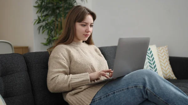 Evdeki Kanepede Dizüstü Bilgisayar Kullanan Genç Sarışın Kadın — Stok fotoğraf