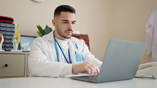 Young Hispanic Man Doctor Using Laptop Working Clinic — Stok fotoğraf