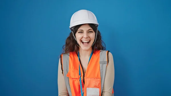 Junge Schöne Hispanische Bauarbeiterin Lächelt Selbstbewusst Vor Isoliertem Blauen Hintergrund — Stockfoto