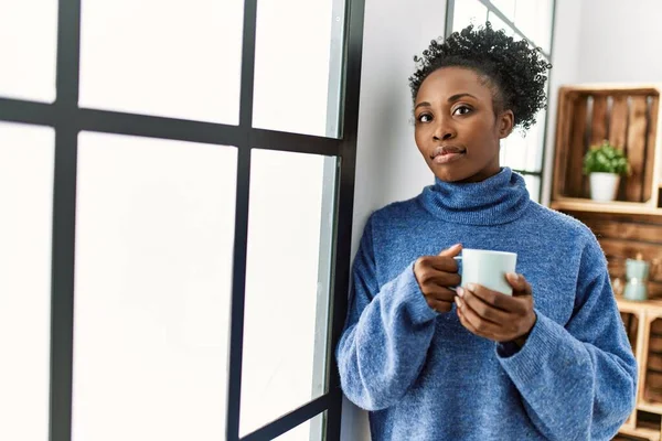 非洲裔美国妇女在家里靠着窗户喝咖啡 — 图库照片