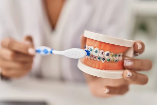 年轻美丽的惊慌失措的女牙医在诊所用括号教授清洁牙齿 — 图库照片
