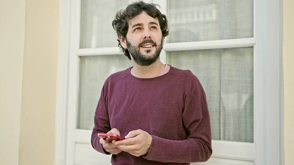 Jonge Spaanse Man Met Behulp Van Smartphone Glimlachen Straat — Stockfoto