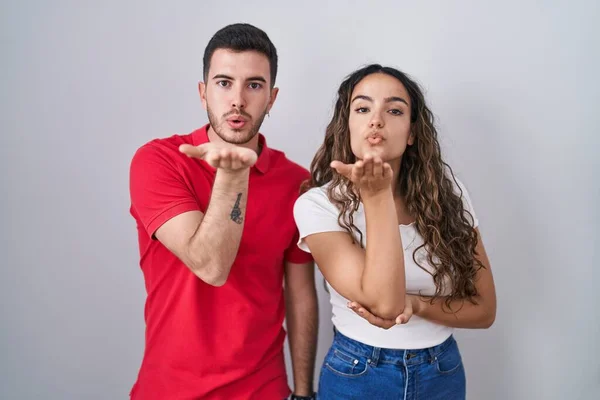 Young Hispanic Couple Standing Isolated Background Looking Camera Blowing Kiss — Stock Photo, Image