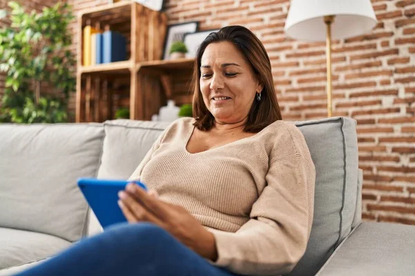 Middle Age Hispanic Woman Using Touchpad Sitting Sofa Home — Stock fotografie