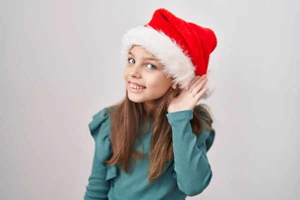 Kafkasyalı Küçük Bir Kız Noel Şapkası Takmış Kulaklarında Gülümseyerek Dedikodu — Stok fotoğraf