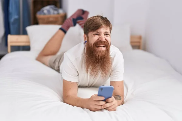 Jovem Ruiva Homem Usando Smartphone Deitado Cama Quarto — Fotografia de Stock