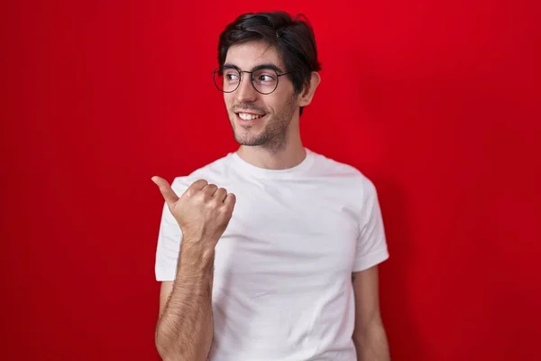 Молодий Іспаномовний Чоловік Стоїть Над Червоним Тлом Посміхаючись Щасливим Обличчям — стокове фото