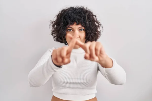 头发卷曲的西班牙裔妇女站在孤立的背景音乐排斥表情上 交叉手指做阴性手势 — 图库照片