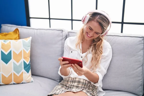 Young Blonde Woman Watching Video Smartphone Sitting Sofa Home — Stockfoto
