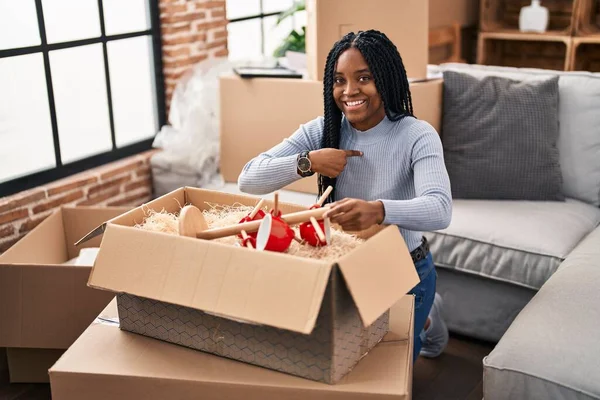 Африканская Американка Переезжает Новый Дом Открывая Коробки Указывая Пальцем Себя — стоковое фото