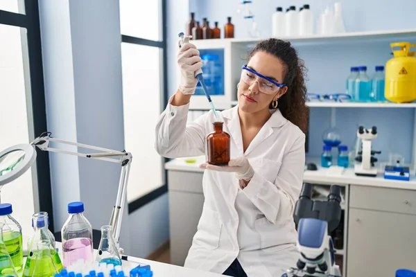 Young Beautiful Hispanic Woman Scientist Pouring Liquid Bottle Laboratory — Stock Photo, Image