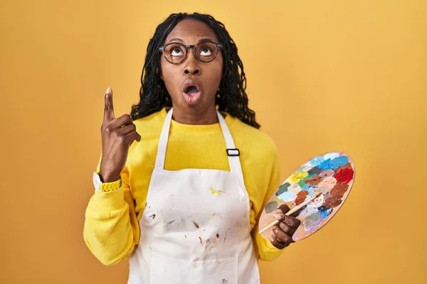 African Woman Holding Painter Palette Amazed Surprised Looking Pointing Fingers — Stock Photo, Image