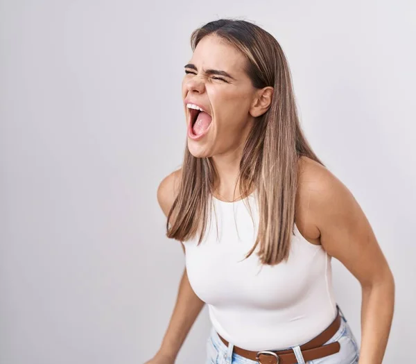 ヒスパニック系の若い女性が白い背景に怒って立っていると怒っている不満と激怒叫び 怒りで叫んで 怒りと攻撃的な考え方 — ストック写真