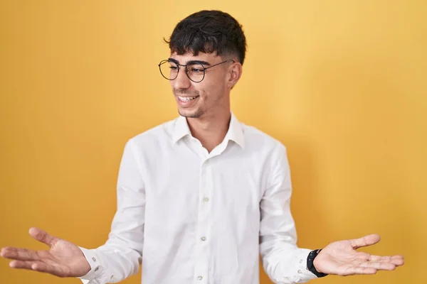 Sarı Arka Planda Duran Spanyol Genç Adam Gülümsüyor Elini Açık — Stok fotoğraf