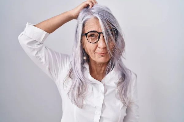 中年妇女戴着眼镜站在白色的背景上 对问题感到困惑和好奇 拿不定主意 手拿着头思考 沉思的概念 — 图库照片