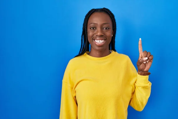 Mooie Zwarte Vrouw Staan Blauwe Achtergrond Tonen Wijzen Met Vinger — Stockfoto
