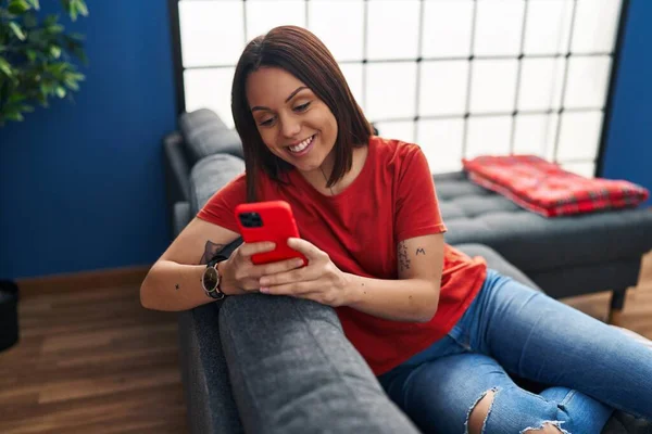 Young Beautiful Hispanic Woman Using Smartphone Sitting Sofa Home — Stock Photo, Image