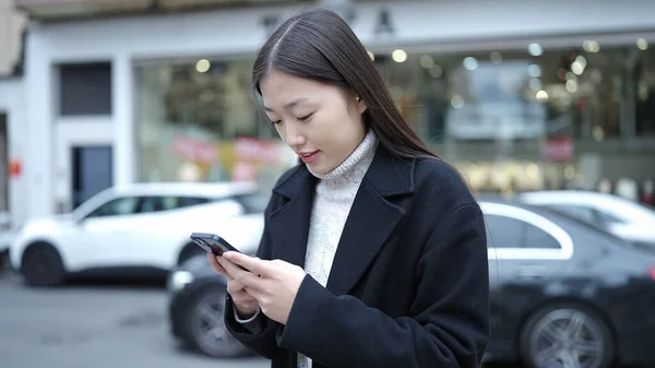 Jonge Chinese Vrouw Glimlachen Zelfverzekerd Met Behulp Van Smartphone Straat — Stockfoto