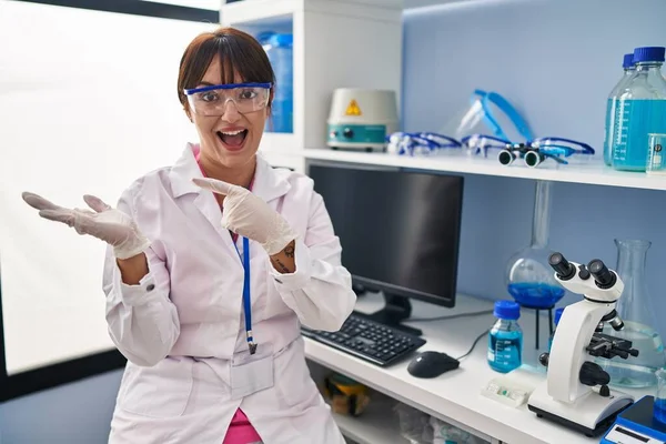 Joven Morena Trabajando Laboratorio Científico Sorprendida Sonriendo Cámara Mientras Presenta — Foto de Stock