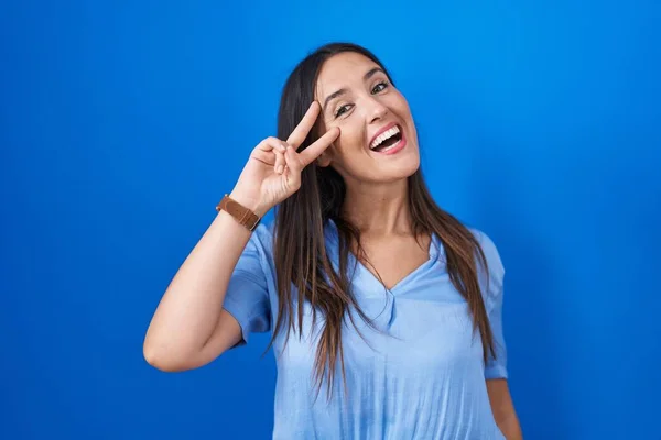 Jonge Brunette Vrouw Staande Blauwe Achtergrond Doen Vrede Symbool Met — Stockfoto