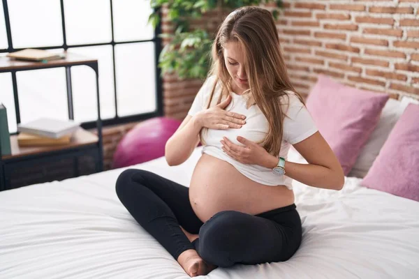 Jonge Zwangere Vrouw Zitten Bed Onderzoeken Borst Met Handen Slaapkamer — Stockfoto