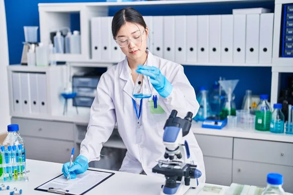 中国の女性科学者は実験室で文書上の液体の書き込みを測定 — ストック写真
