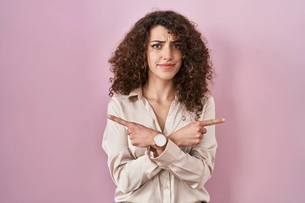Hispanic Woman Curly Hair Standing Pink Background Pointing Both Sides — Foto de Stock