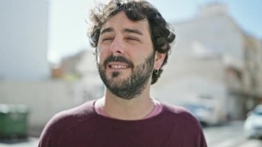 Sokakta kendinden emin gülümseyen İspanyol genç adam.