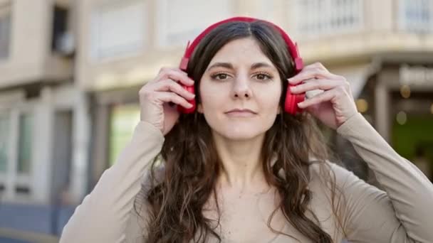 Joven Hermosa Mujer Hispana Sonriendo Confiada Escuchando Música Calle — Vídeo de stock