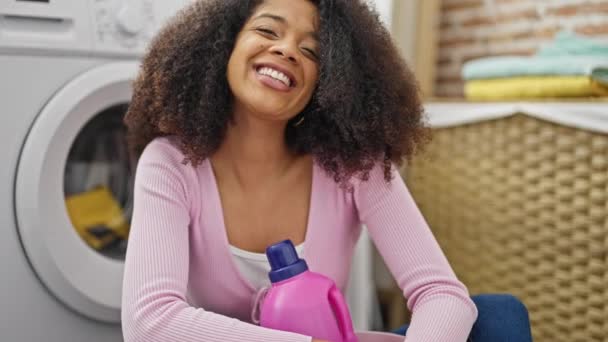 Afrikansk Amerikansk Kvinna Tvättar Kläder Håller Tvättmedel Flaska Tvättstuga — Stockvideo