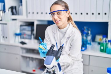 Genç bilim kadını gülümsemesi laboratuardaki test tüpünde kendinden emin bir yazı.