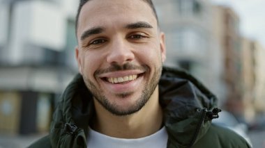 Sokakta kendinden emin gülümseyen İspanyol genç adam.