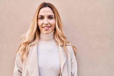 Young blonde woman smiling confident standing over isolated white background