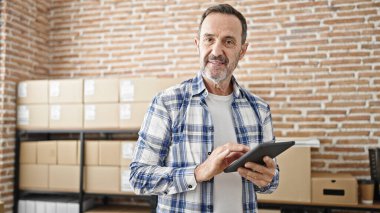 Middle age man ecommerce business worker using touchpad at office