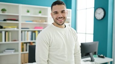 Young hispanic man student smiling confident standing at library university