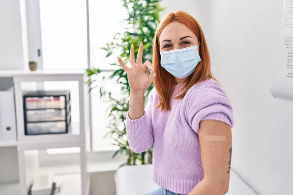 Young Woman Getting Vaccine Showing Arm Band Aid Doing Sign — Photo